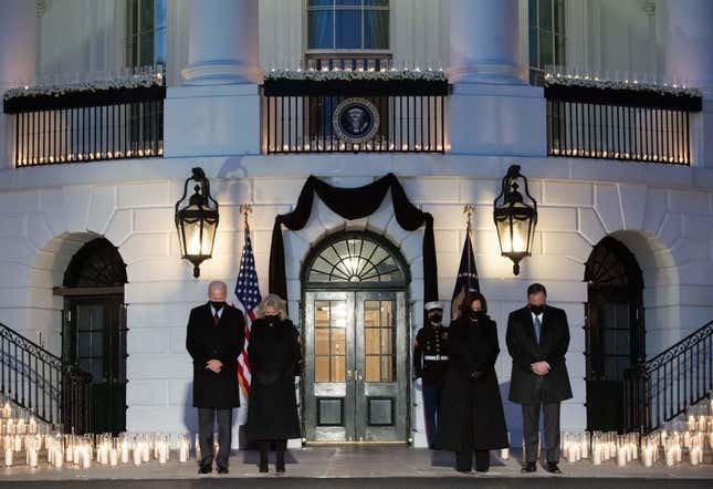 US President Joe Biden, First Lady Jill Biden, US Vice President Kamala Harris and her husband, Doug Emhoff, hold a moment of silence during a candelight ceremony in honor of those who lost their lives to Coronavirus on the South Lawn of the White House in Washington, DC, February 22, 2021.