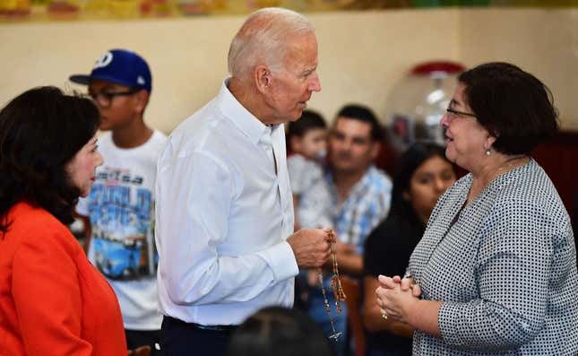 Joe Biden is given a rosary while meeting with patrons, alongside Hilda Solis (L), Former United States Secretary of Labor and a member of the Los Angeles County Board of Supervisors in Los Angeles, Calif. on July 19, 2019.