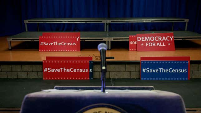 Signs sit behind the podium before the start of a press conference April 3, 2018, with the then New York attorney general Eric to announce a multistate lawsuit to block the Trump administration from adding a question about citizenship to the 2020 census form. 