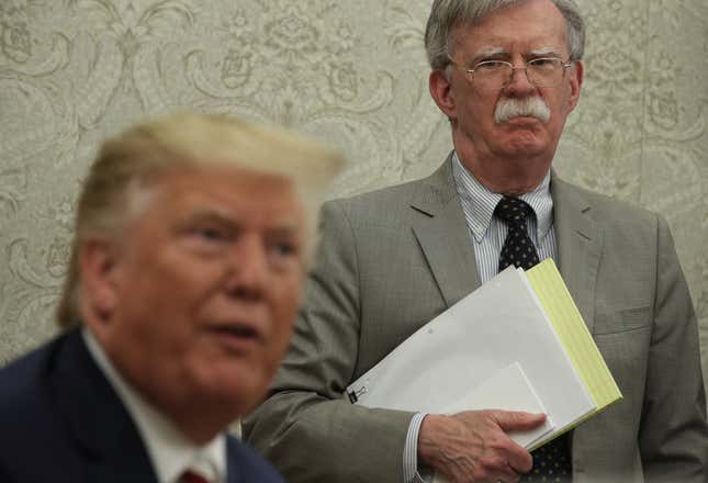  U.S. President Donald Trump speaks to members of the media as National Security Adviser John Bolton listens during a meeting with President of Romania Klaus Iohannis in the Oval Office of the White House August 20, 2019 in Washington, DC. 