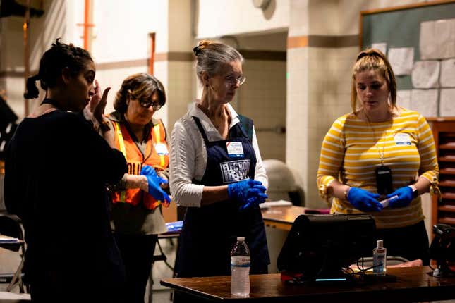 Election workers wait for voters during the Florida primary election at Doris &amp; Phil Sanford Fire Rescue Station Coral Gables in Miami, Florida, on March 17, 2020.