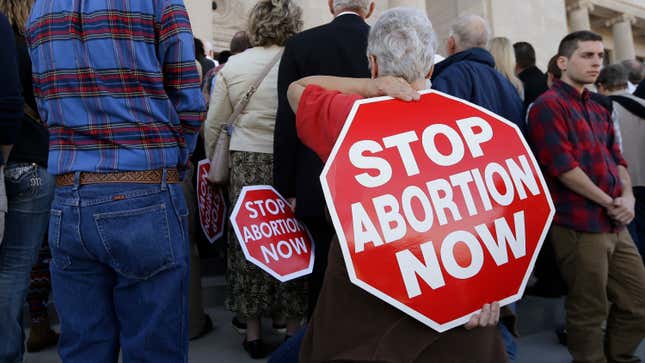 A woman carries an anti-abortion sign on her back during a rally at the Arkansas state Capitol in Little Rock, Ark., Sunday, Jan. 18, 2015