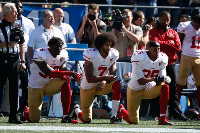 Colin Kaepernick #7 and members of the San Francisco 49ers kneel during the national anthem prior to the game against the Seattle Seahawks at CenturyLink Field on September 25, 2016 in Seattle, Washington.