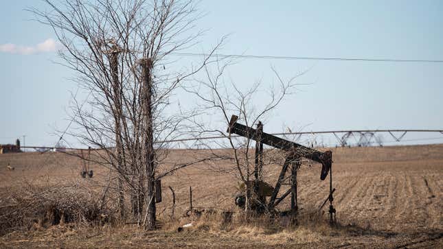 An idled pump jack, once used to extract crude oil from the ground, sits rusting above a well in a farmers field near Ridgway, Illinois.