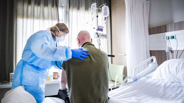 An attending physician listens to the breathing of a patient who is recovering after admission to an intensive care unit in the coronavirus patient nursing department of The HMC Westeinde Hospital in The Hague on April 4, 2020.