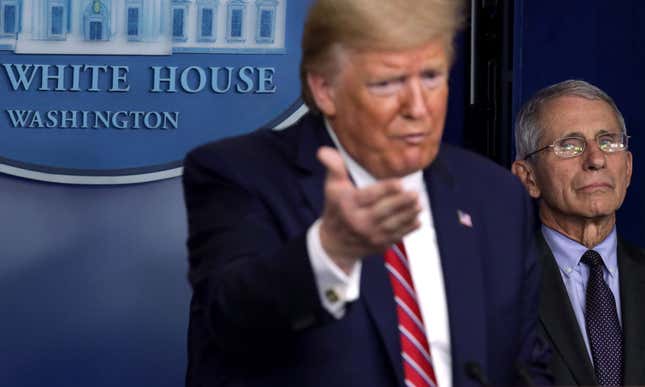 President Donald Trump speaks as Dir. of the National Institute of Allergy and Infectious Diseases Dr. Anthony Fauci looks on during a news briefing.