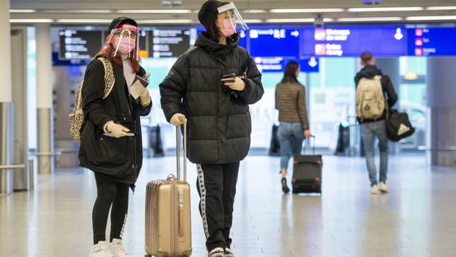 Travelers wear face masks at Germany’s Frankfurt Airport.