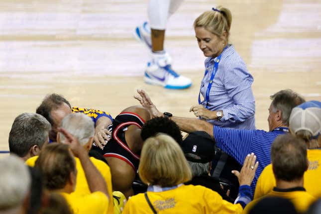 Kyle Lowry of the Toronto Raptors is pushed by Warriors minority investor Mark Stevens (blue shirt) after falling into the seats after a play on June 05, 2019 in Oakland, Calif.