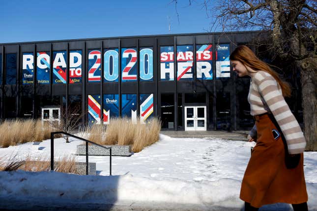 A woman walks past a sign displayed on a building a Drake University that reads “Road To 2020 Starts Here” on February 2, 2020 in Des Moines, Iowa. Tomorrow, Iowa voters will go to their local precincts to caucus for a one of several presidential candidates.