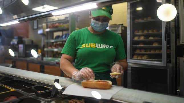 A worker wears a face mask while making a sandwich in a Subway store on June 12, 2020 in London, England.