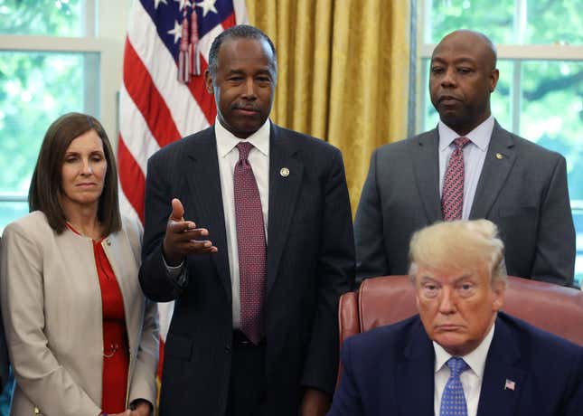 Housing and Urban Development Secretary Ben Carson (2L) speaks before President Donald Trump. 