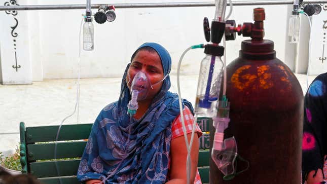 A covid-19 patient breathes with the help of oxygen provided by a Gurdwara, a place of worship for Sikhs, under a tent installed along the roadside in Ghaziabad, India on April 28, 2021. 