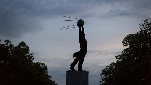 A statue representing a man holding the Sputnik satellite, the namesake of the Sputnik V vaccine, is seen after sunset on June 7, 2018 in Samara, Russia