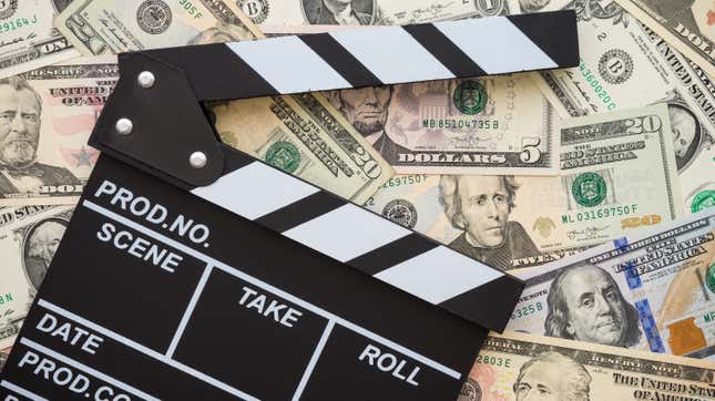 Cinema clapperboard on US dollars banknote bill background