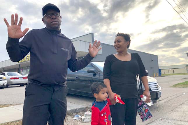 Rapper turned political candidate, Brad “Scarface” Jordan, left, visits  with voter Michele Lemon and her son outside of an early voting location  in the Sunnyside neighborhood of Houston, Texas.