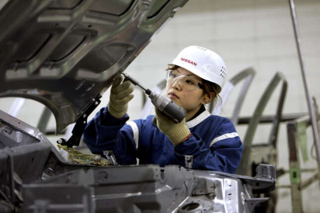 A young worker screws a bolt into the hood at a plant manufacturing car bodies at Nissan Motor Co.’s Tochigi Plant in Kaminokawa-Machi in Tochigi prefecture, north of Tokyo, Friday, June 15, 2007.